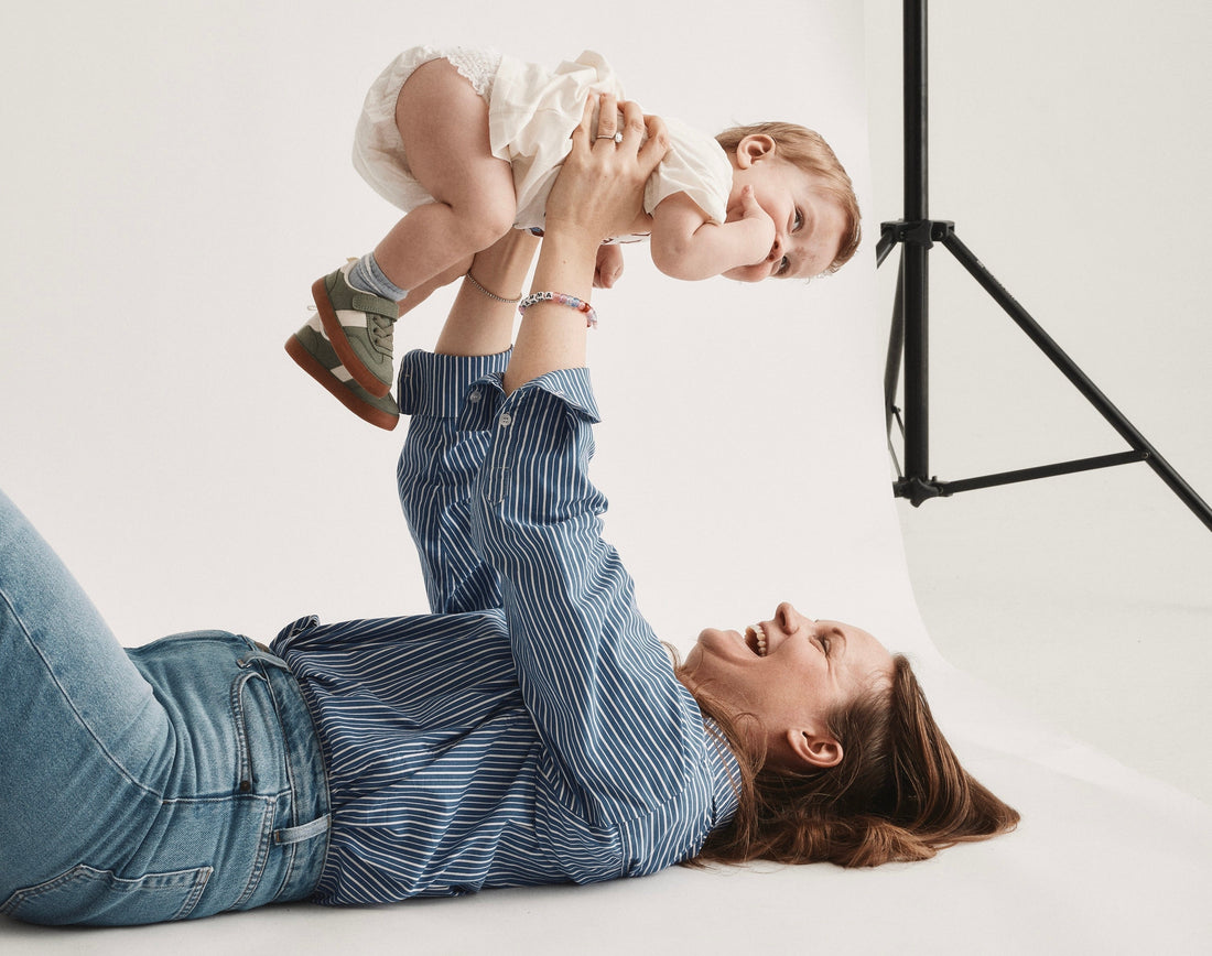 Parent who is holding their child over her head, while the child wears a diaper from Bammies